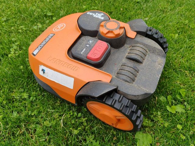 Robot de tonte : surface, pente, guidage et sécurité à vérifier Robot tondeuse orange posé sur un gazon fraîchement coupé