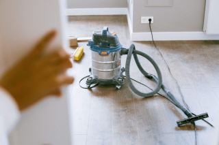 Aspirateur eau et poussière en inox posé sur un parquet en rénovation