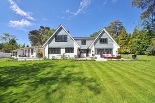 Pelouse tondue en bandes régulières devant une maison blanche